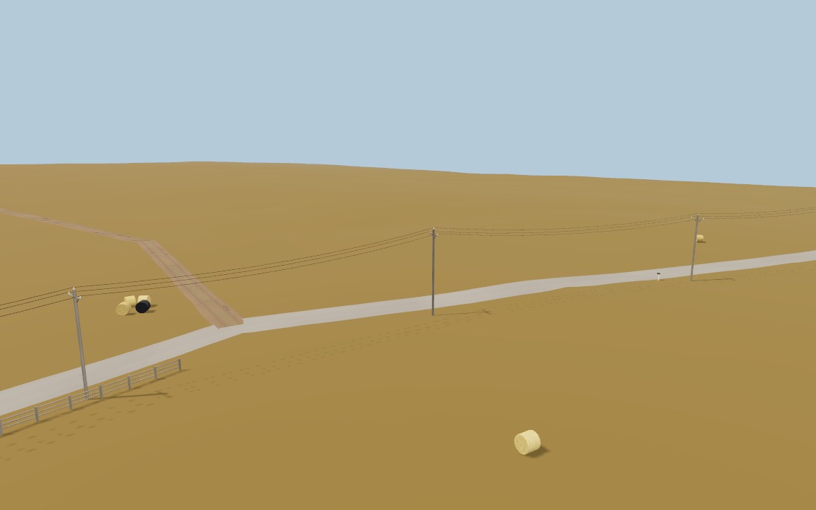 A gravel road with power poles, a rail fence and hay bales